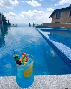 a drink sitting next to a swimming pool at Aurora Kopaonik in Raška +7 photos