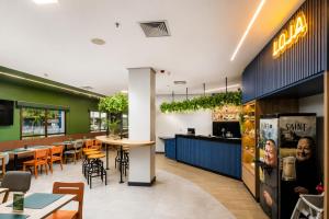 a restaurant with a bar and tables and chairs at Comfort Hotel Joinville in Joinville