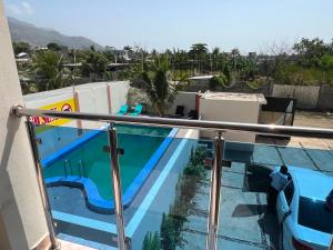 a view of a swimming pool from the balcony of a house at Darlouis hotel bar piscine in Cap Haïtien