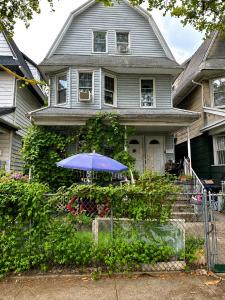 a house with a blue umbrella in front of it at CLASSICAL AMERICAN Homestay HOUSE in Brooklyn