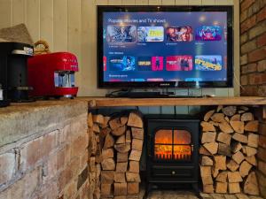 a fireplace with a television on top of it at The Old Forge in Bishop Wilton