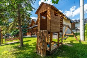 a wooden play structure in the yard of a house at DW KINGA Domki całoroczne 6 os z widokiem na Tatry in Kacwin