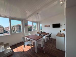 a dining room with a table and chairs and windows at Mare di Roma 2 in Lido di Ostia