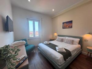 a bedroom with a bed and a chair and a window at Mare di Roma 2 in Lido di Ostia +50 photos