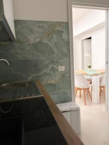 a kitchen with a marble wall with a table at Sorrento Gem House in Meta +17 photos