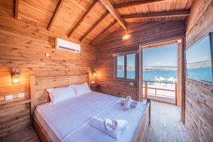 a bed in a wooden room with a large window at Akyalı Boutique Hotel in Guvercinlik +54 photos