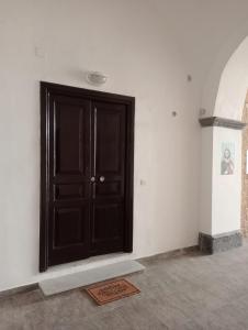 a black door in a white room with a rug at Sorrento Gem House in Meta
