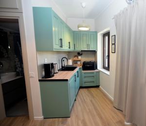 a kitchen with mint green cabinets and a sink at ANNA's House in Mythimna +10 photos