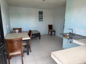a kitchen with a sink and a table and chairs at HM cuarteria cangrejos in Cabo San Lucas