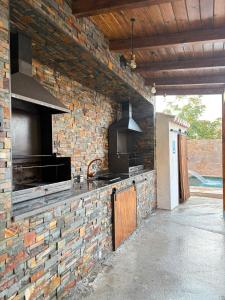 an outdoor kitchen with a brick wall and a stove at Cuevas Uropia in Graena