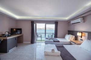 a hotel room with two beds and a balcony at Akyalı Boutique Hotel in Guvercinlik