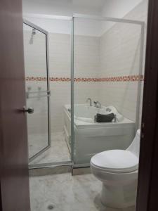 a bathroom with a tub and a toilet and a shower at La Clandestina in Chachagüí