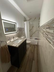 a white bathroom with a sink and a toilet at Tamuna's Home in Hamilton +28 photos
