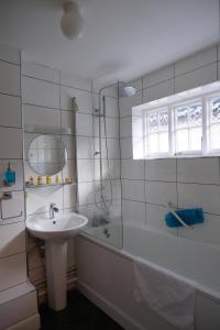 a bathroom with a sink and a shower and a tub at The St Crispin Inn in Worth