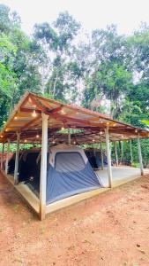 a tent with a roof in a field at Seravelle Adventure Camping in Kitulgala