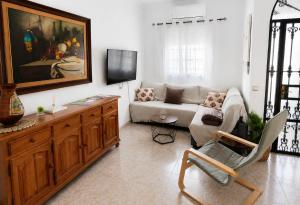 a living room with a couch and a tv at Casa Paco & Carmela in Algodonales
