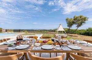 a wooden table with food on it next to a pool at The Retreat Villa in Lefkada