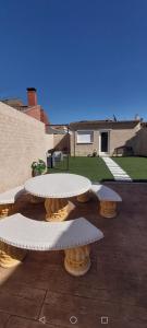 a patio with two picnic tables and a house at El Colibrí de Taraza in San Pedro de Latarce