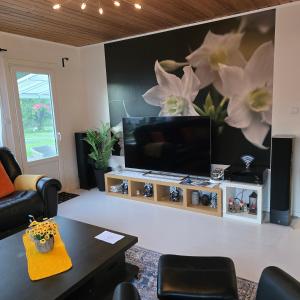 a living room with a flat screen tv on a wall at Stuga Ani Wellness & Sauna in Svartå
