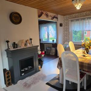 a living room with a fireplace and a dining table at Stuga Ani Wellness & Sauna in Svartå