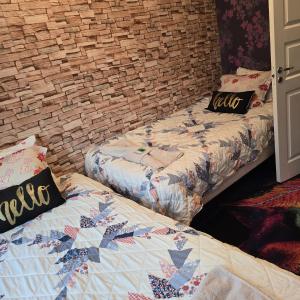 two beds sitting next to a brick wall at Stuga Ani Wellness & Sauna in Svartå