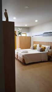 a bedroom with a large bed with yellow pillows at Rua Grande Hotel in Viana do Castelo