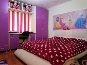 a bedroom with a bed and a desk and purple walls at Casa Stefania in Eforie Nord
