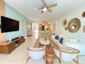 a living room with a couch and a tv at Charming two-bedroom apartment in Las Terrenas in Las Terrenas