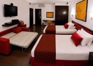 a hotel room with two beds and a tv at hostal cf bed y breakfast in Cali