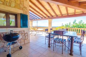 a patio with a table and chairs and a grill at Can Teco in Porto Cristo