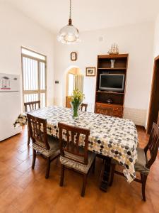 a dining room with a table and chairs and a television at Casa Giulia in Pula