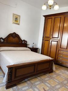 a bedroom with a bed and a wooden cabinet at Casa Giulia in Pula +1 photo