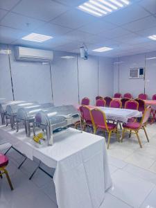 a room filled with tables and chairs with tables at Rahat Alubur Hotel in Medina