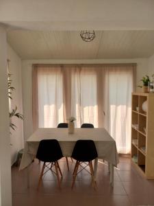 a dining room table with four chairs in front of a window at Poço Cávado House T3 in Geres +8 photos