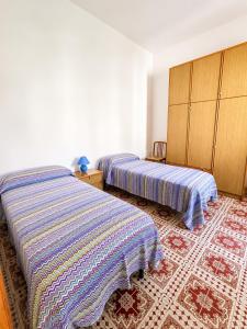 a bedroom with two beds and a rug at Casa Giulia in Pula