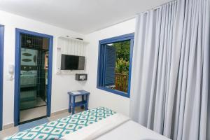 a bedroom with a bed and a window at Pousada Paraíso Almada in Ubatuba