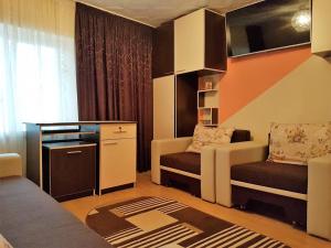 a small living room with a couch and a chair at Casa Stefania in Eforie Nord