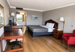 a hotel room with a bed and a desk and a desk at Hospitality House Union City I 69 US 51, TN in Union City