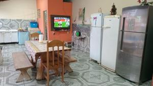 a kitchen with a table and two refrigerators at Refúgio a 300m da prainha! in Rifaina
