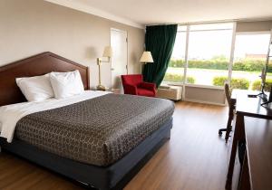 a hotel room with a bed and a red chair at Hospitality House Union City I 69 US 51, TN in Union City
