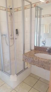 
a bathroom with a shower, sink, and toilet at Hotel-Cafe Rathaus in Bad Abbach
