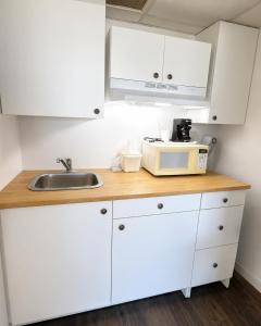 a kitchen with white cabinets and a sink and a microwave at Hospitality House Union City I 69 US 51, TN in Union City