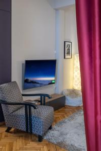 a living room with a chair and a tv at 4 Travelers in Thessaloniki