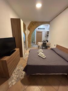 a bedroom with a bed and a flat screen tv at Kalgheros in Agrigento +75 photos