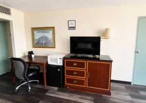 a hotel room with a desk and a television on a dresser at Hospitality House Union City I 69 US 51, TN in Union City