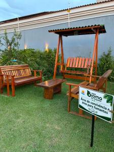 two benches and a gazebo next to a sign at Casa Bioma da Chapada in Chapada dos Guimarães