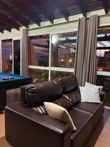 a living room with a leather couch and a pool table at Casa Bioma da Chapada in Chapada dos Guimarães +43 photos