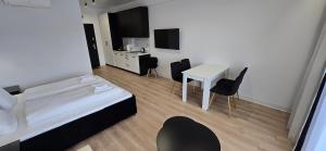 a bedroom with a bed and a table and chairs at White Pearls Apartaments Dąbki in Dąbki