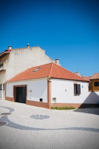a white building with a red roof on a street at Loft beach in Vieira de Leiria