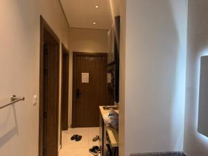 a hallway with a door to a room with shoes on the floor at Apartment in As Salam Rd in Medina